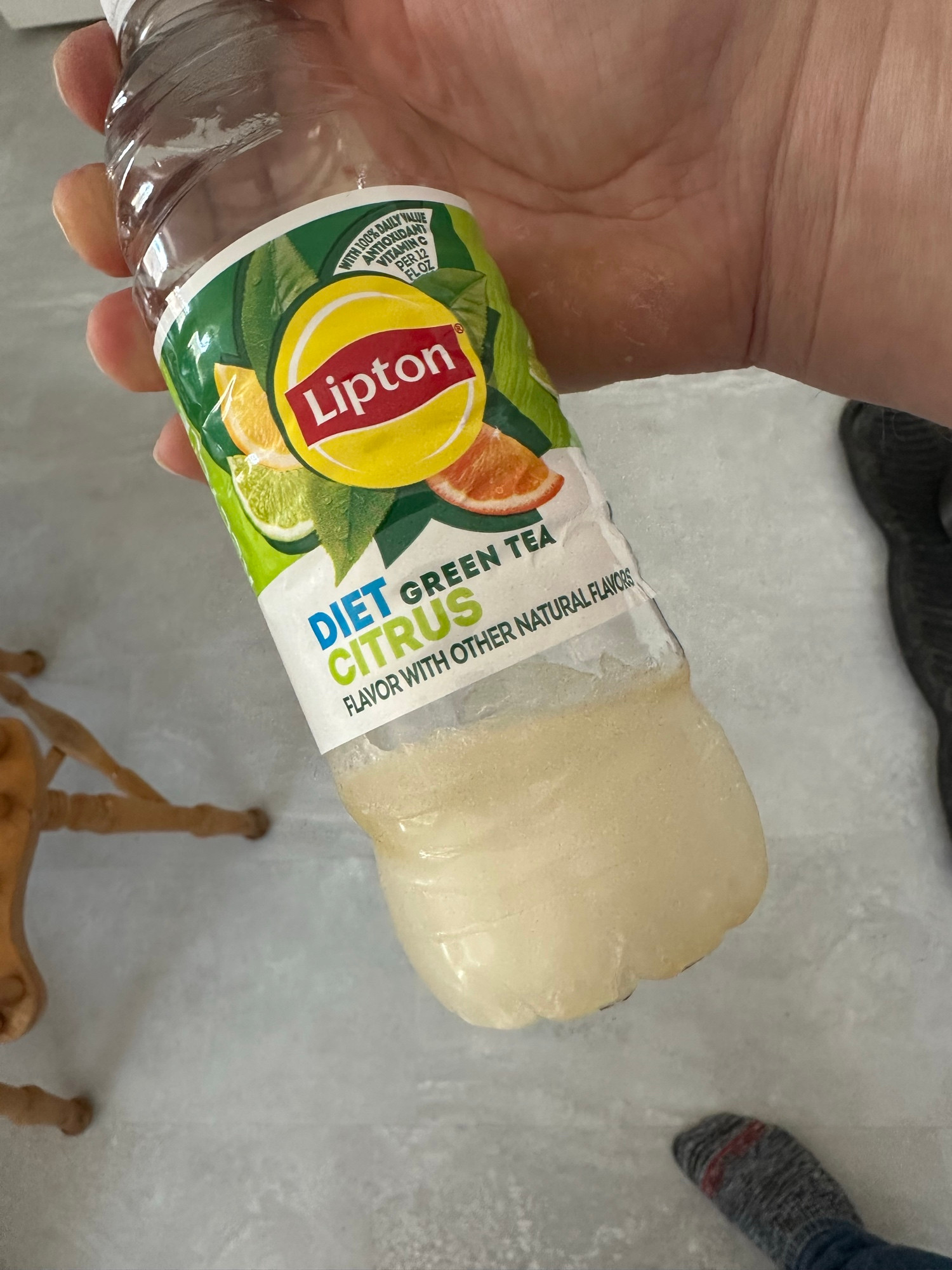 a bottle of iced tea where about 1/4 of it is frozen solid