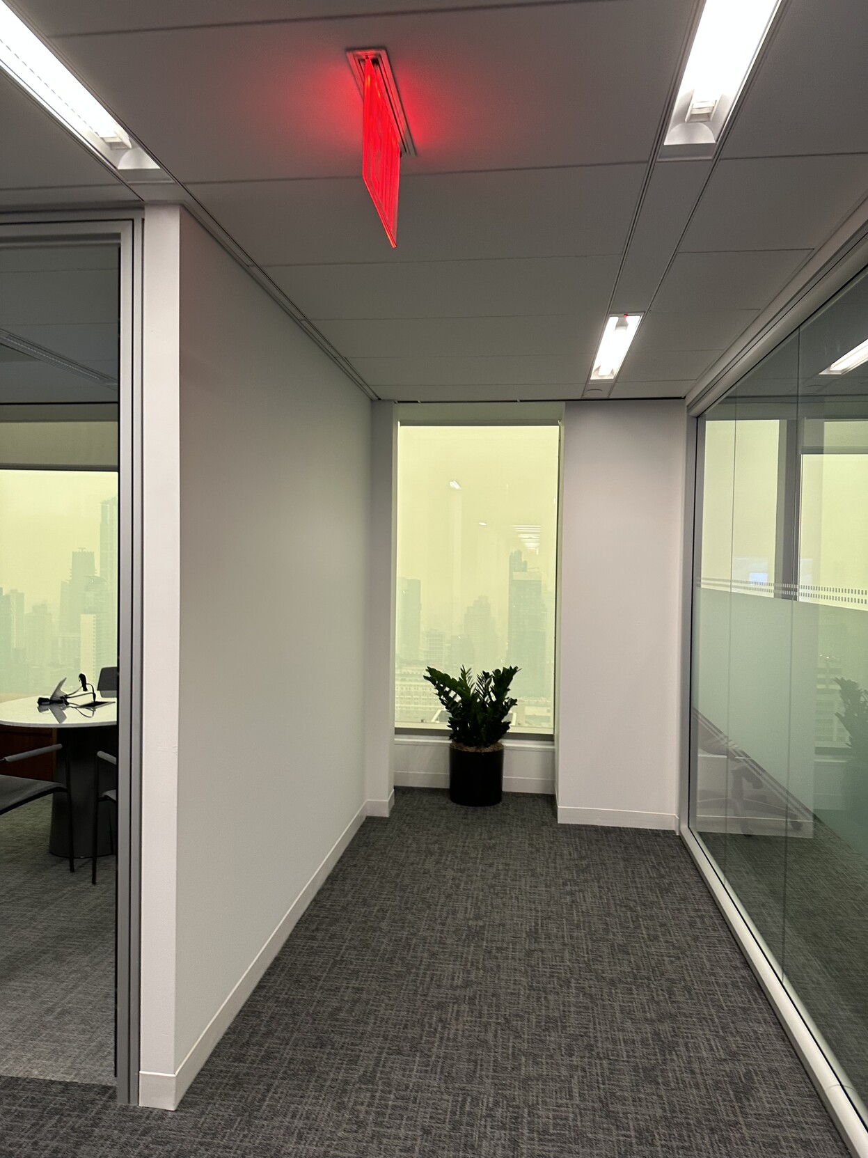 a photo down the hallway towards a window in an office building in new york city