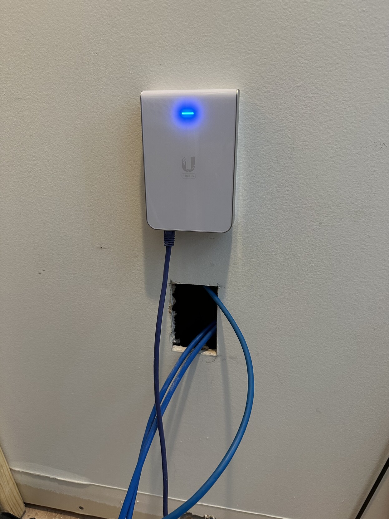a photo of an ubiquiti U6-IW-US wireless access point and ethernet switch, mounted over an opening where i will be installing a box and wiring 4 ethernet drops to rj45 jacks