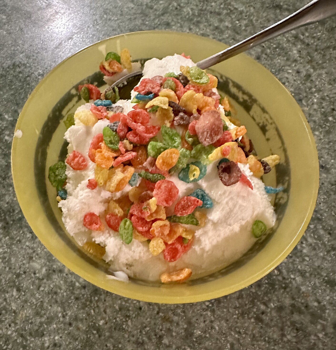 a photo of a bowl of ice cream with fruity pebbles on it. 