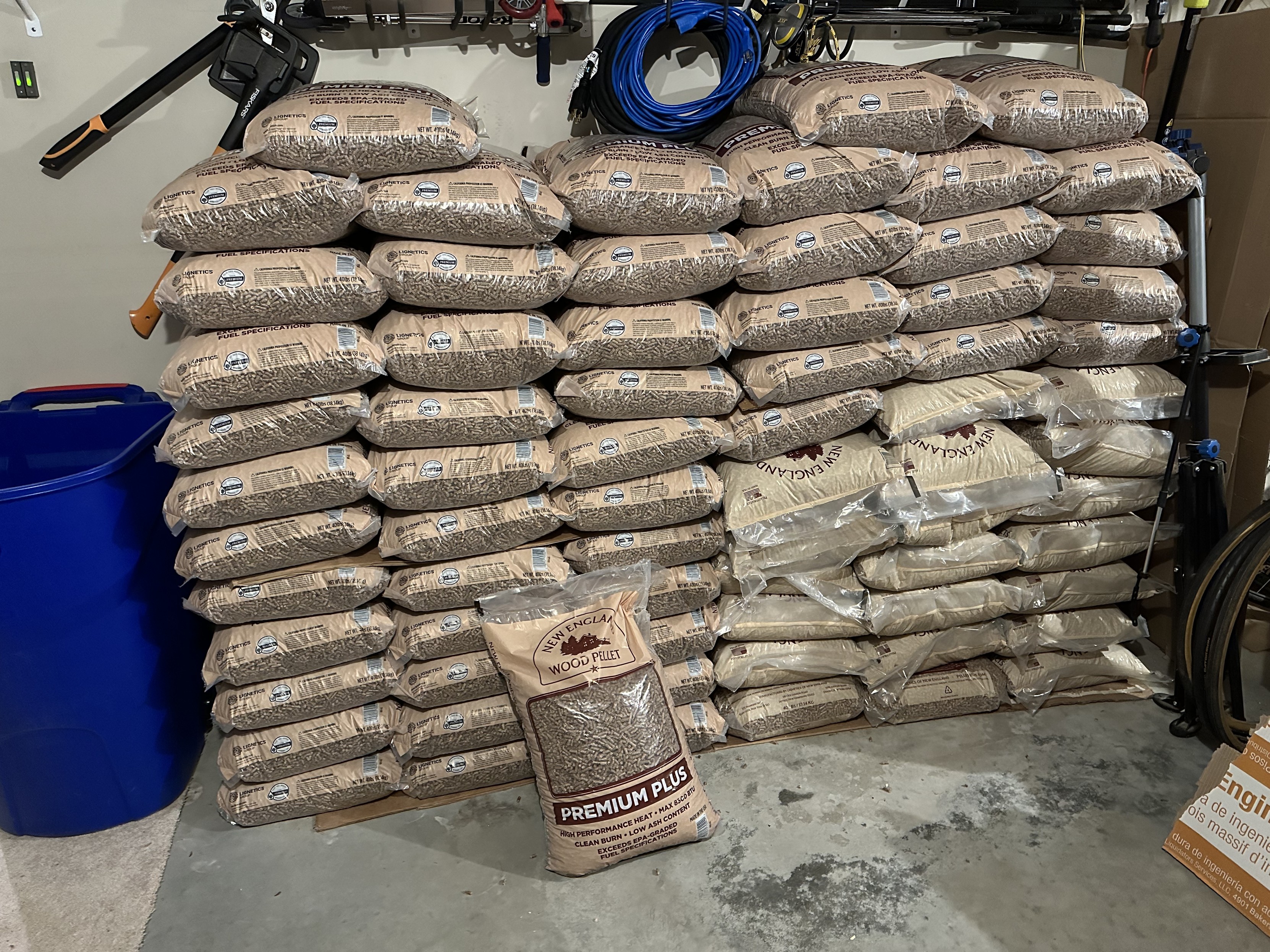 a photo of many bags of wood pellets stacked in my garage 