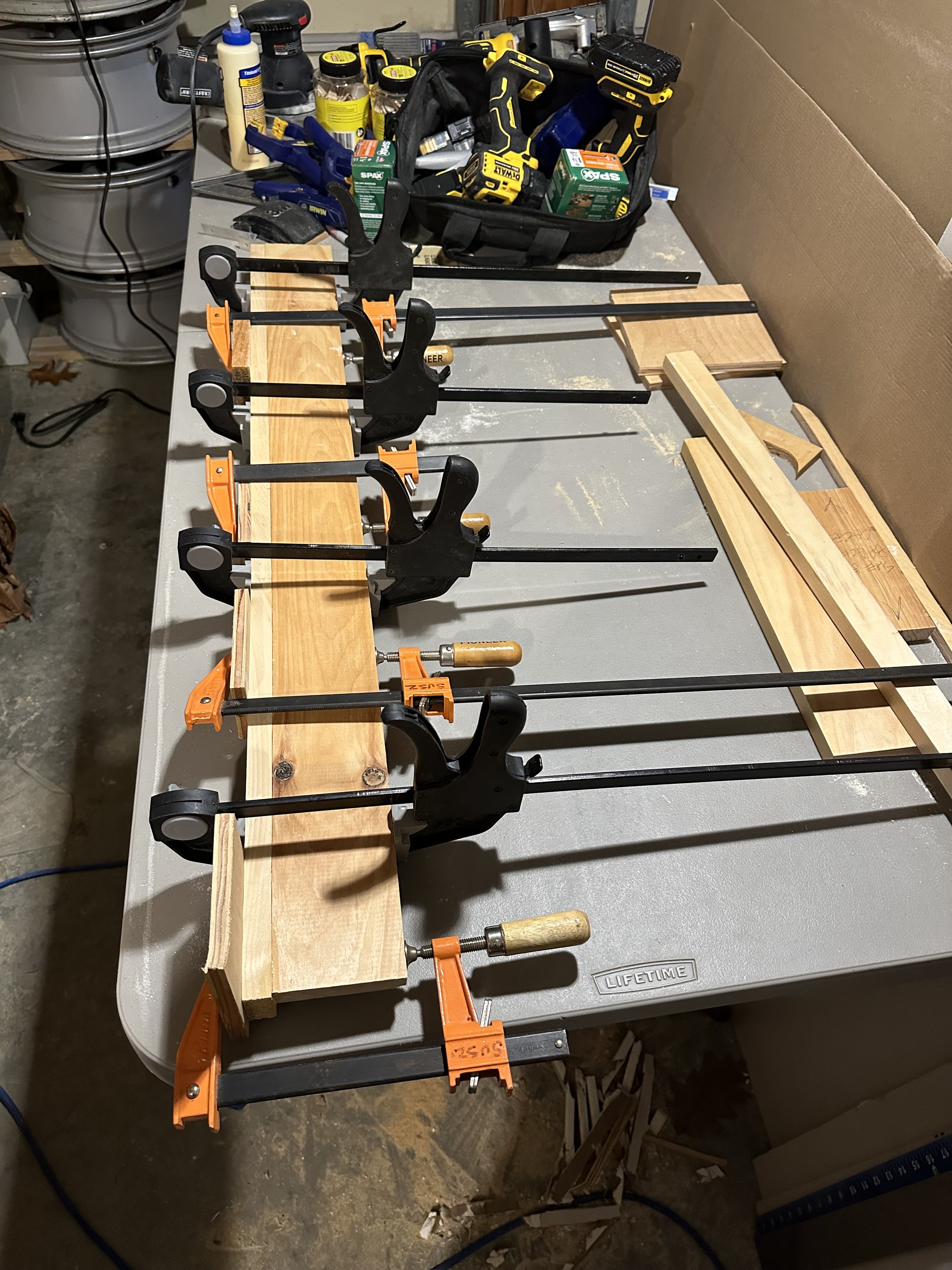 a photo of two boards i have joined together with woodworking biscuits and glue, with 8 clamps applied to hold them together while the glue dries. 