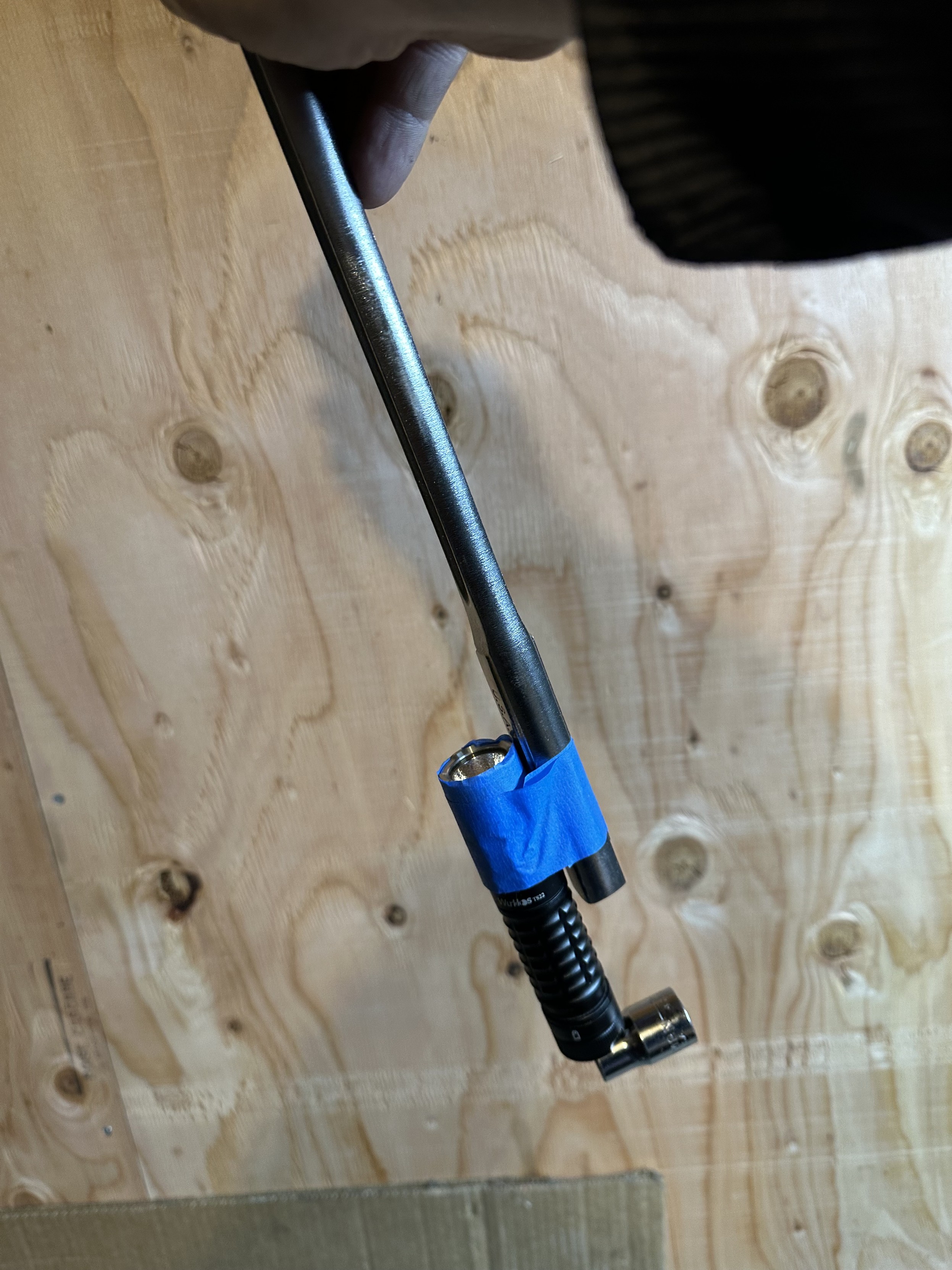 a photo of a long wrench with a flashlight taped to it and a socket stuck to the magnet in the flashlight