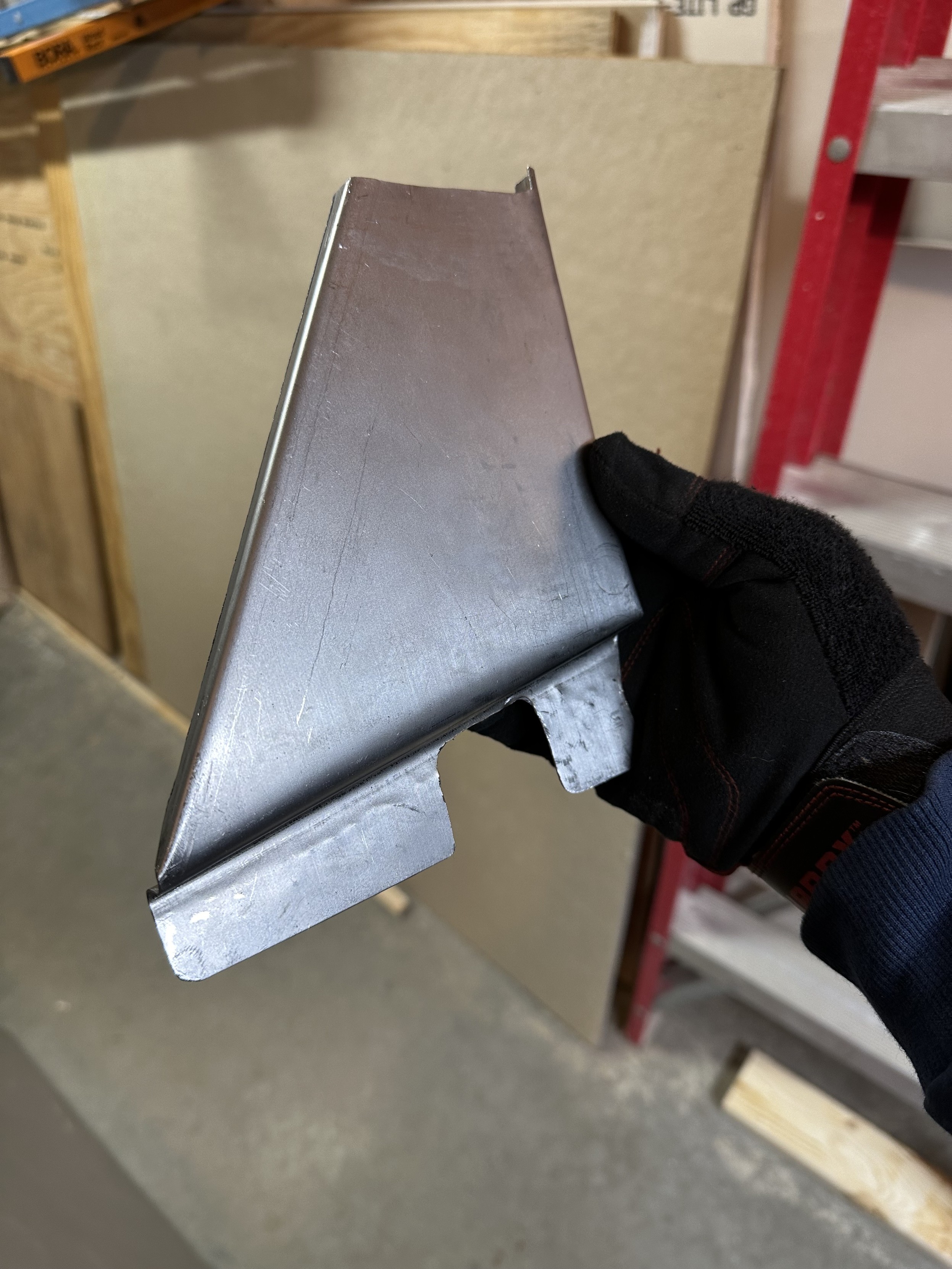 a photo of the metal patch panel i created by bending a piece of flat sheet metal to match the contours of my car where the rust hole was 