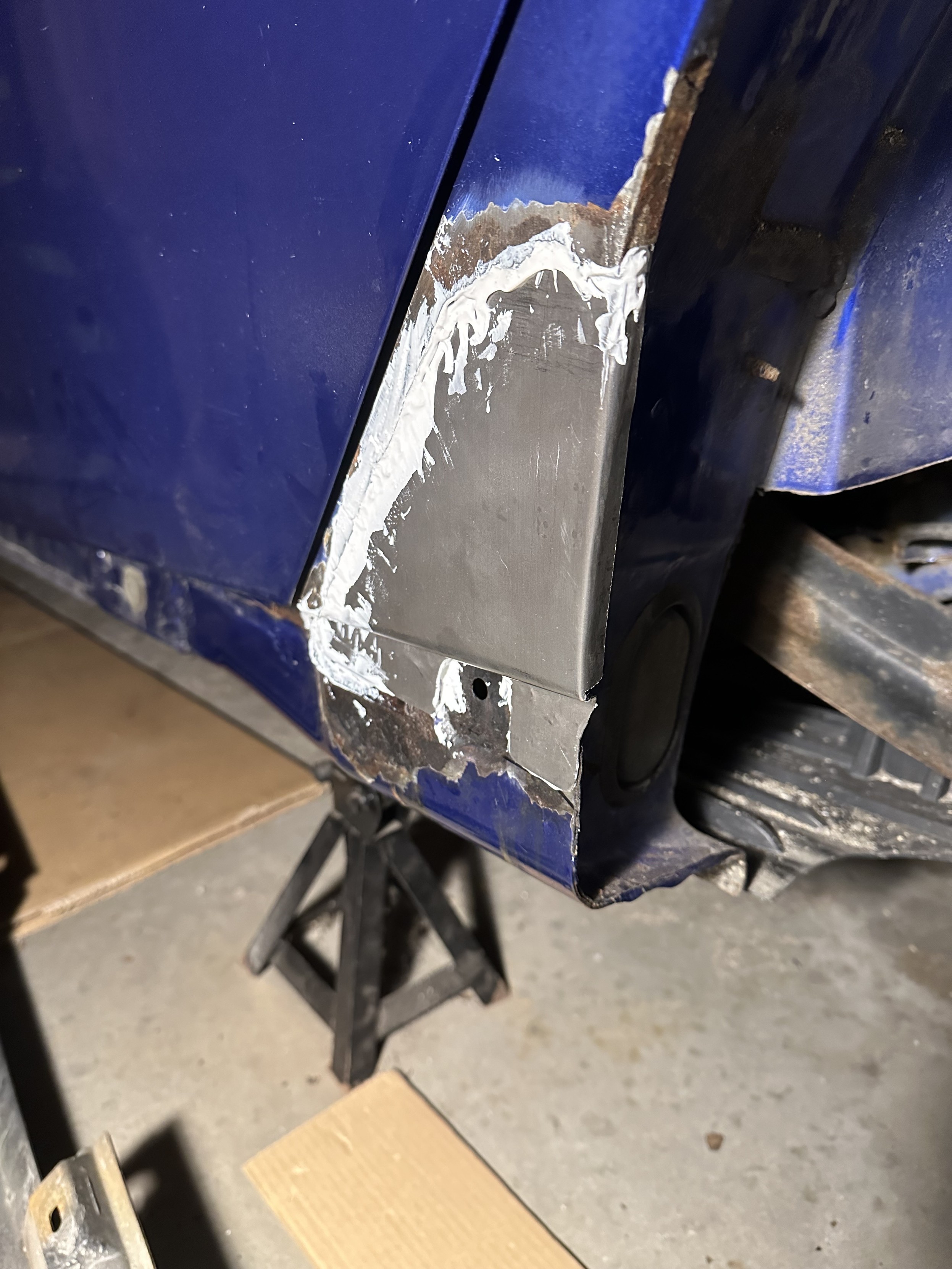 a photo of the patch panel installed in my car using epoxy panel adhesive. it looks messy, it still needs body filler sculpted across the top of it.
