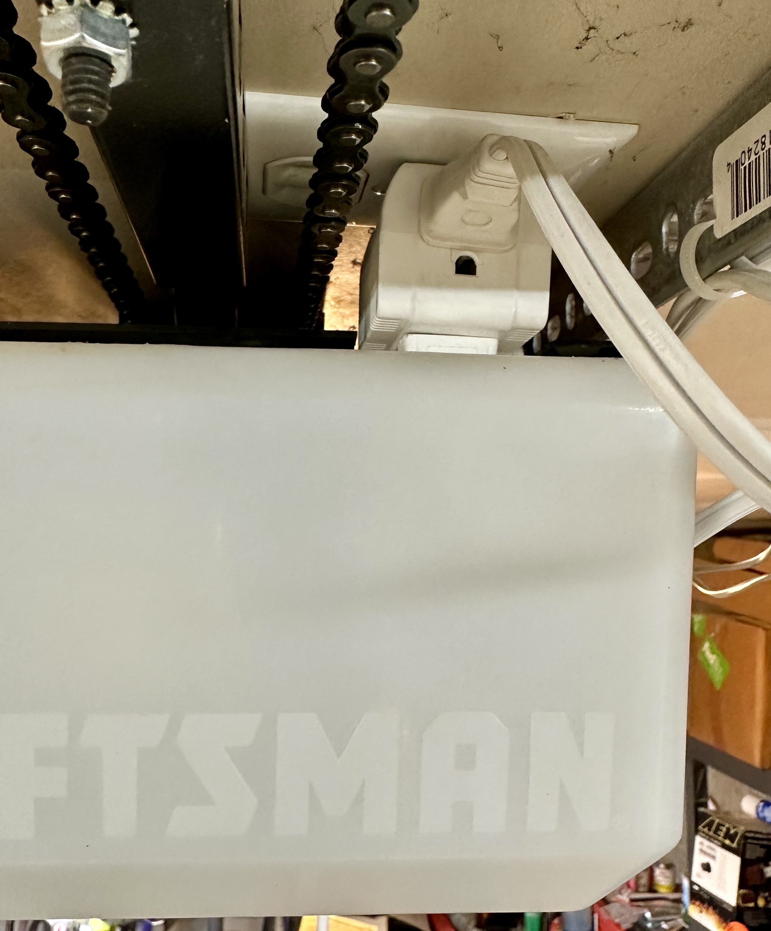 a photo of the outlet above my garage door opener with a 90 degree square plug adapter plugged into the outlet, so i can plug in both the opener and an extension cord