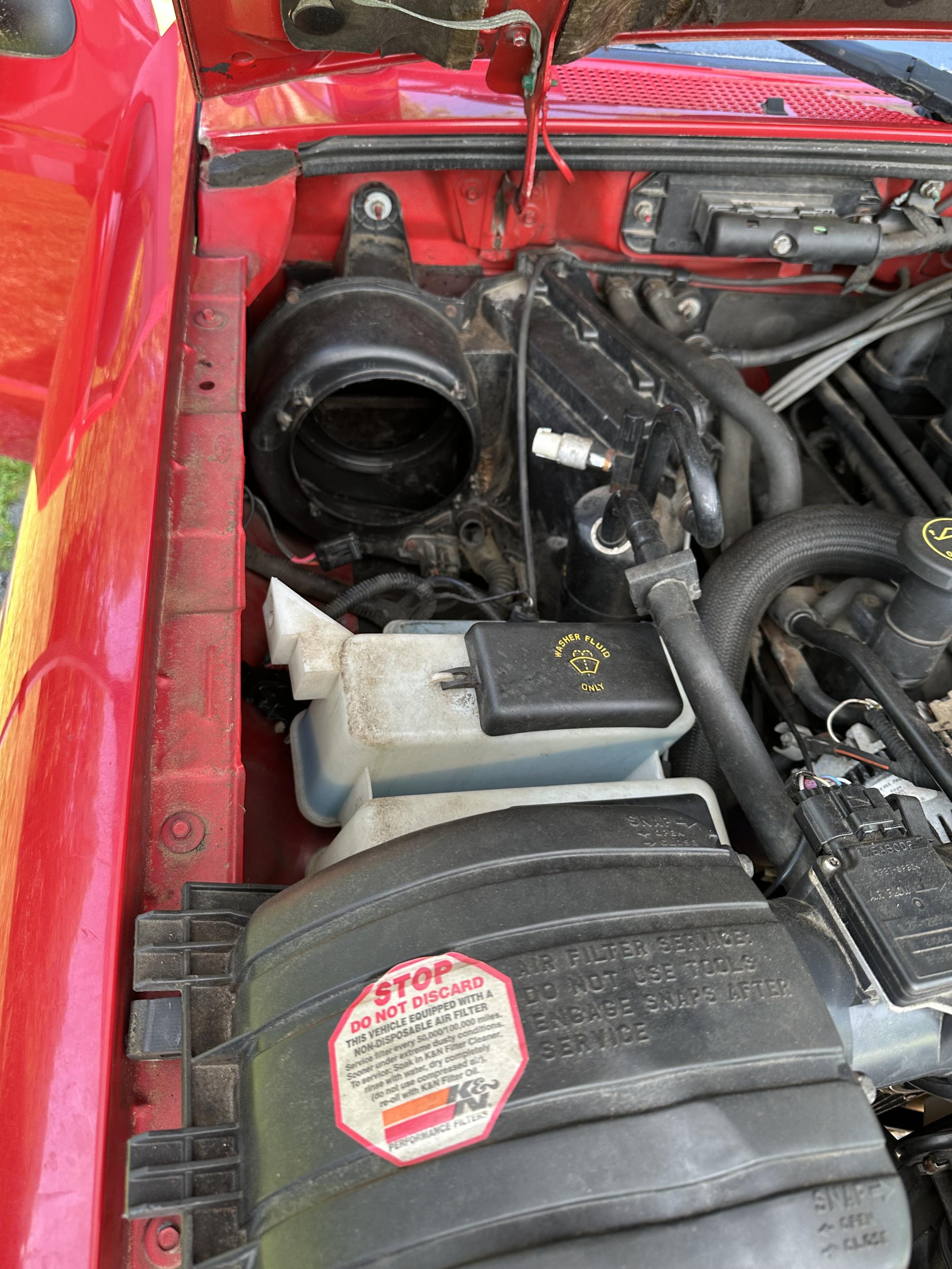 a photo of the engine bay of my truck after i removed the fan blower motor and housing and vacuumed out the airbox