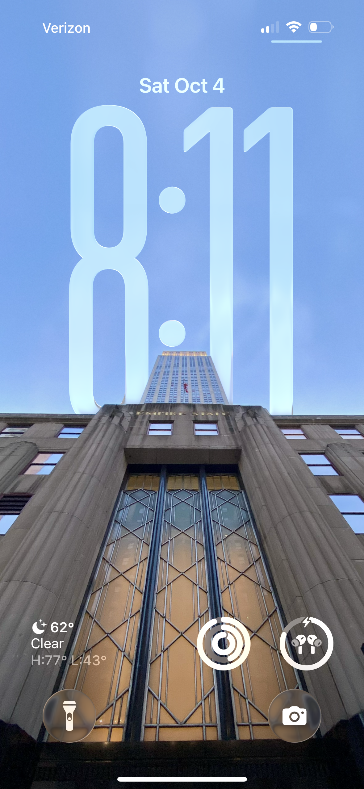 a screenshot of my phone’s lock screen with a photo of the empire state building and the time “8:11” is partially obscured by the building