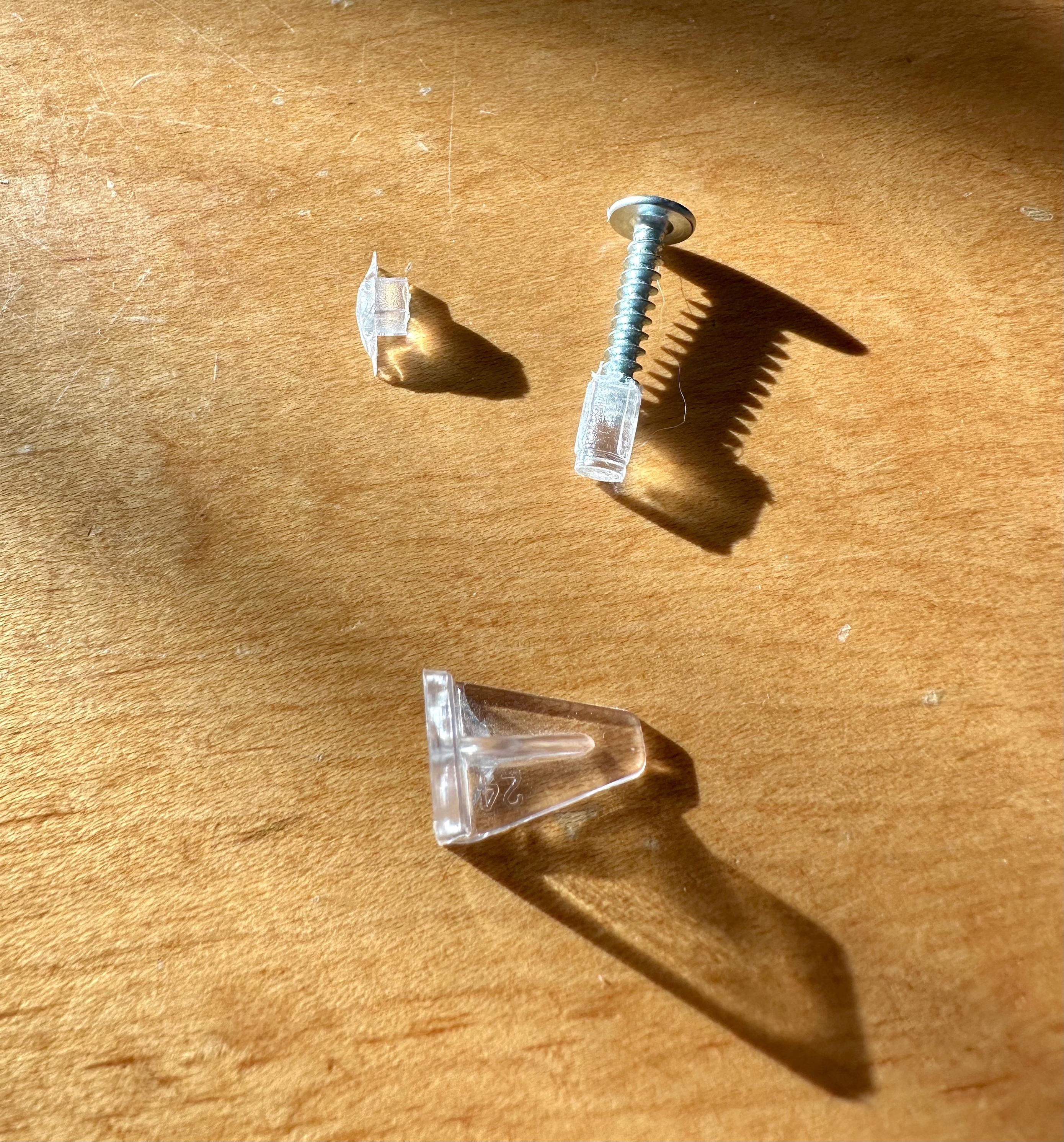 a photo of a broken shelf support, and a screw sticking out of the piece of pin that had broken off