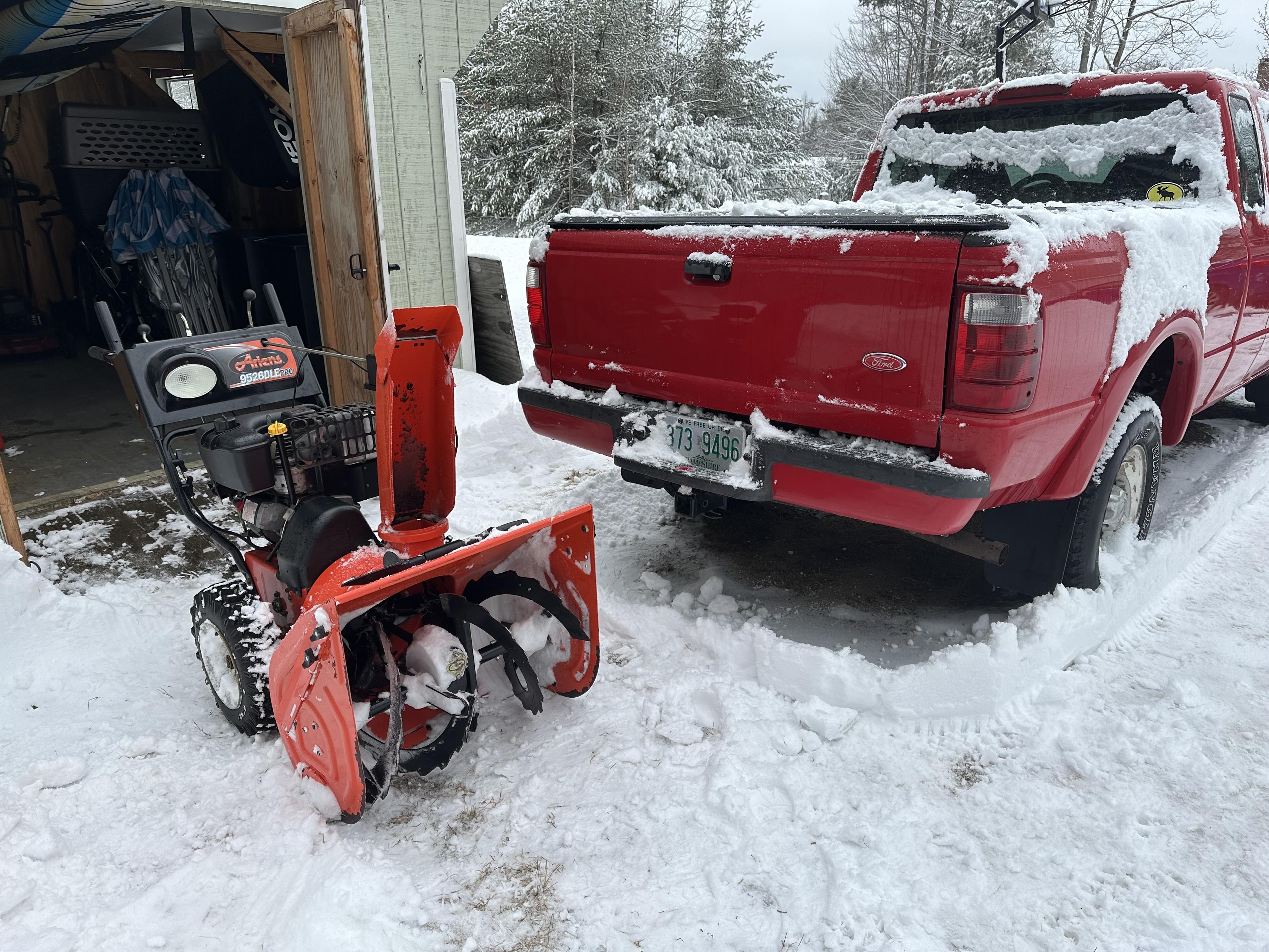 a photo of my snowblower in front of my shed and next to my pickup truck. 