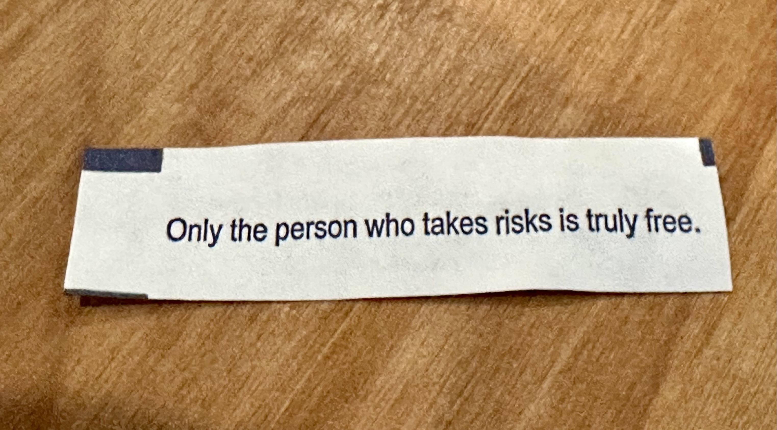 a photo of a fortune cookie fortune that reads: “Only the person who takes risks is truly free.”