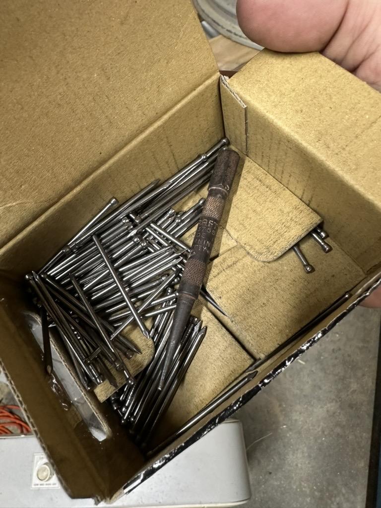 a photo of a box of finish nails and also a nailset inside the box