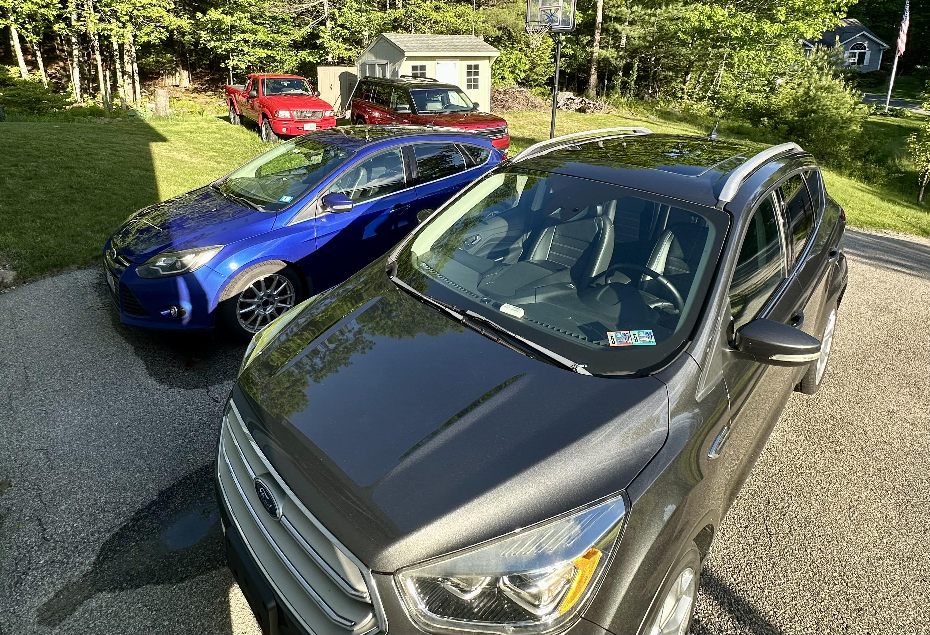 a photo of our cars. from foreground: 2019 Ford Escape, 2013 Ford Focus, 2019 Ford Flex, 2003 Ford Ranger.