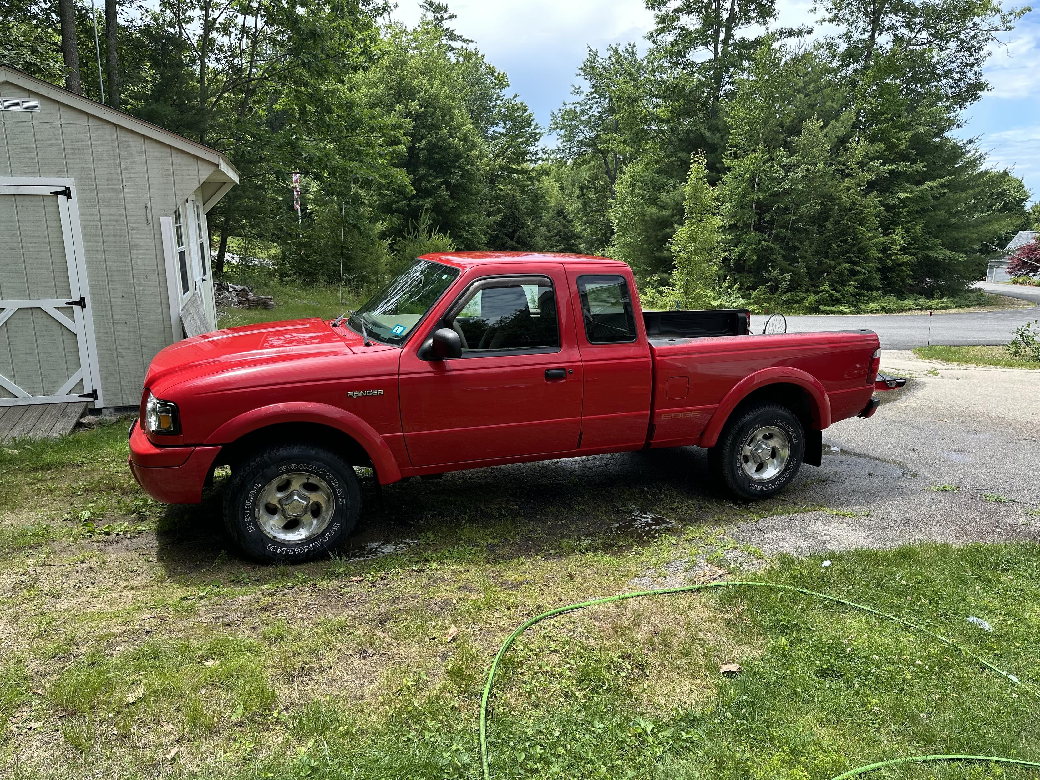 a photo of a red 2003 Ford Ranger Edge extended cab, recently washed.