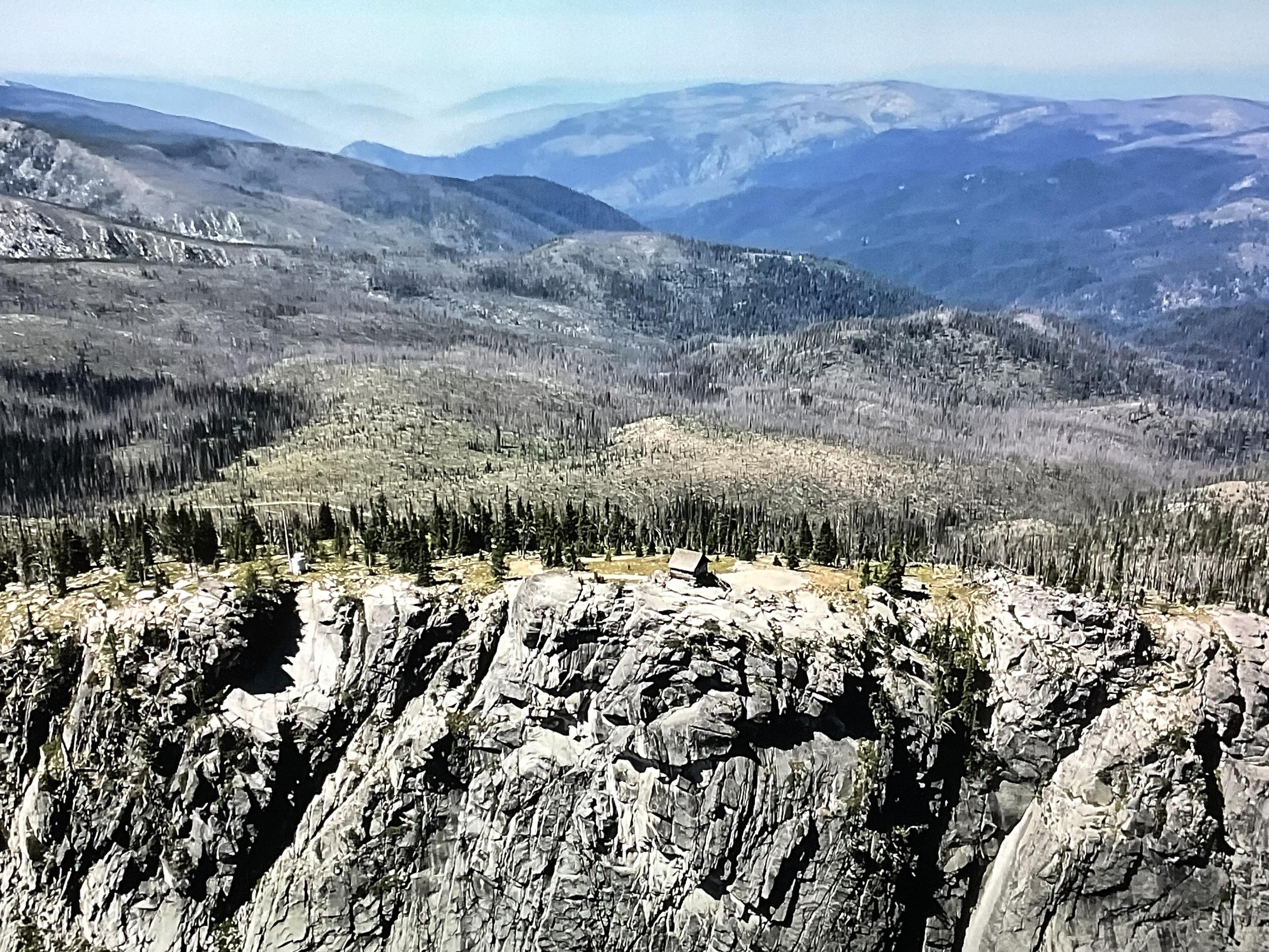 a still from a video with an aerial drone photo of the Burnt Knob Lookout cabin in Idaho