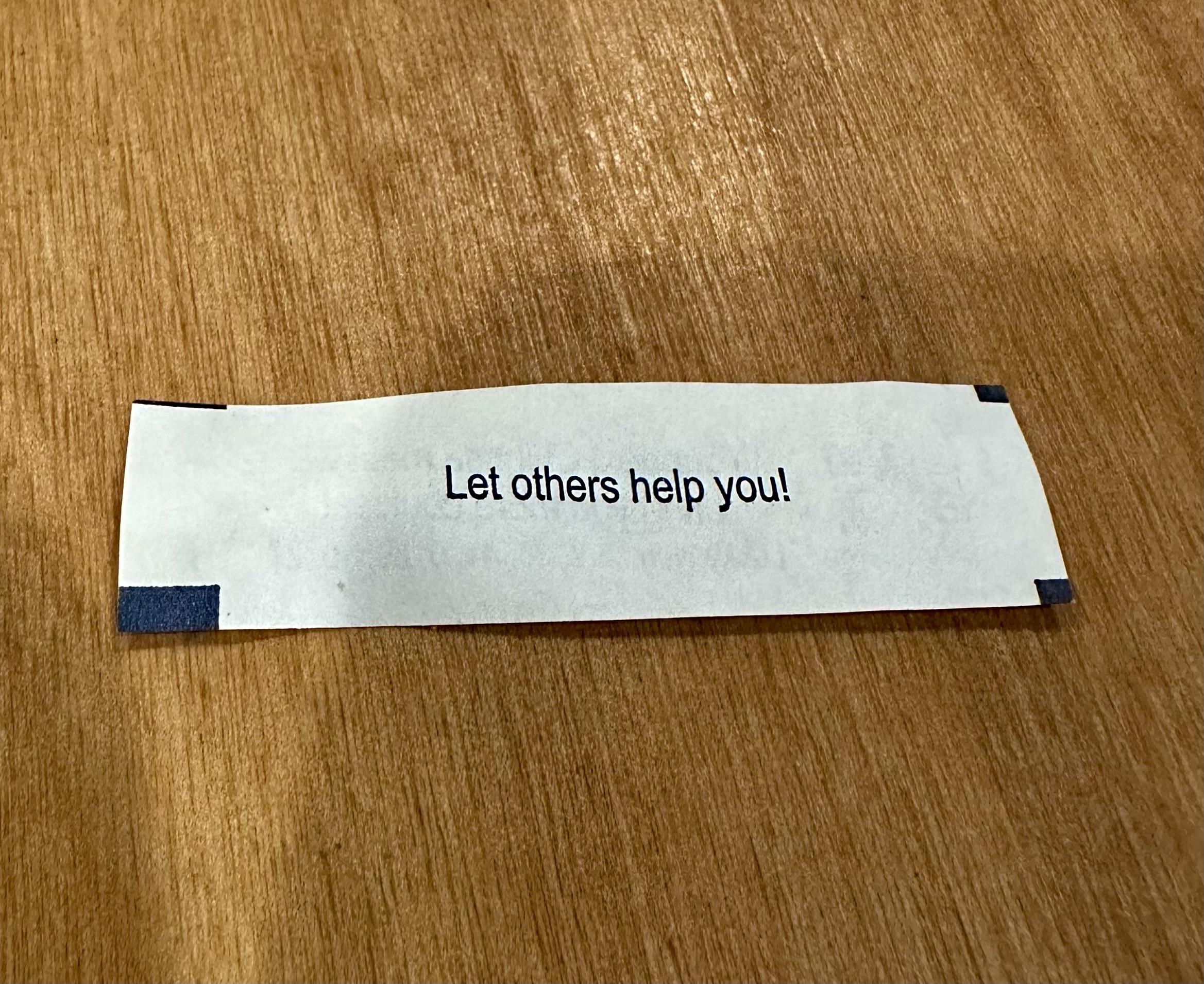 a fortune cookie fortune that reads “let others help you”