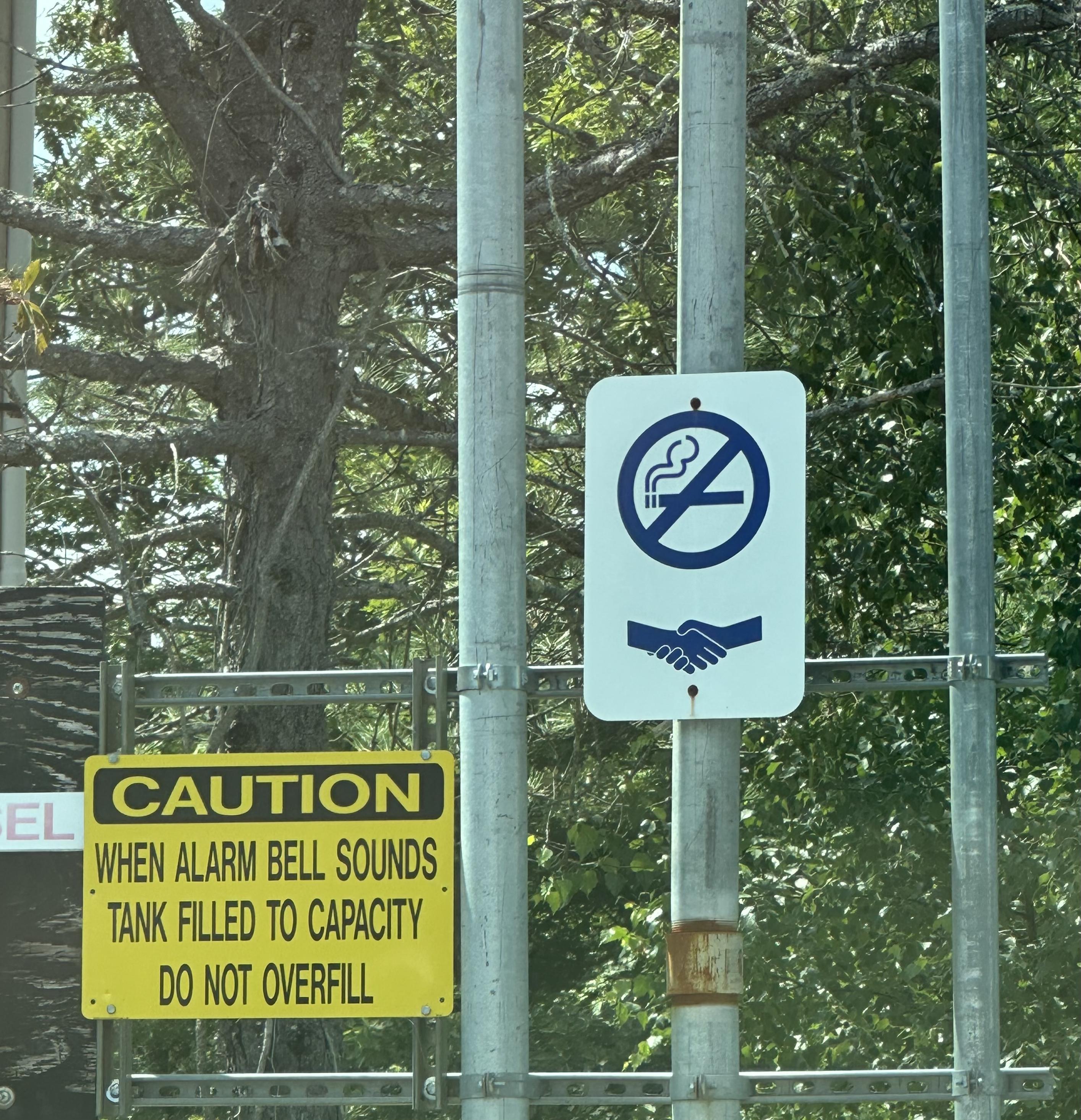 a photo of a couple of signs at a gas station